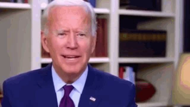 the president of the united states is wearing a blue suit and tie .
