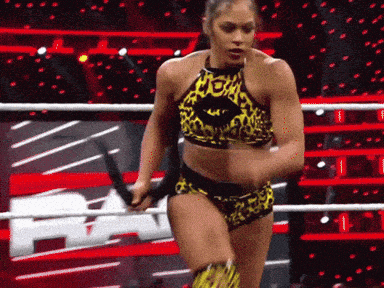 a woman in a leopard print top and shorts is standing in a boxing ring