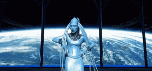 a woman in a silver dress is standing in front of a window looking out to the earth