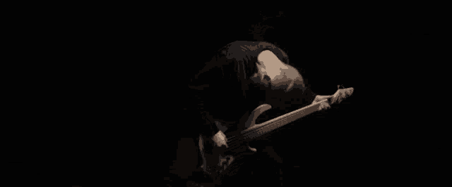 a man with a beard is playing a white bass guitar