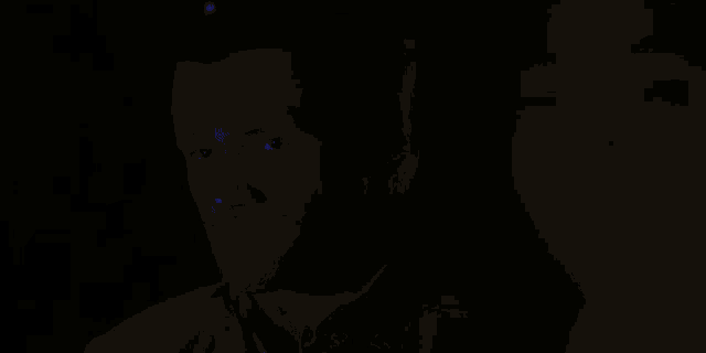 a man is standing in a dark room surrounded by purple smoke and lights .