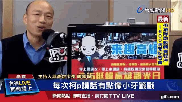 a man is talking into a microphone in front of a screen that says ' ttv live ' on it