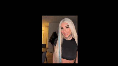a woman with long blonde hair has a tattoo on her forehead