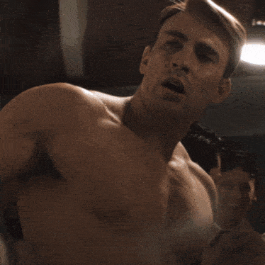 a shirtless man is laying in a machine with his eyes closed