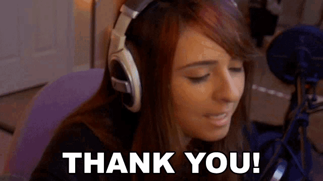 a woman wearing headphones is sitting in front of a microphone and says thank you .