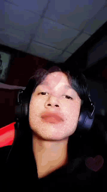 a man wearing headphones is making a funny face .
