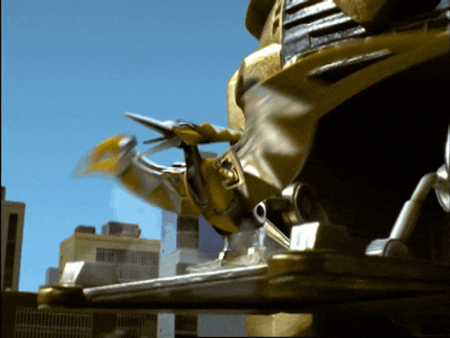 a yellow robot is flying through the air in front of a city