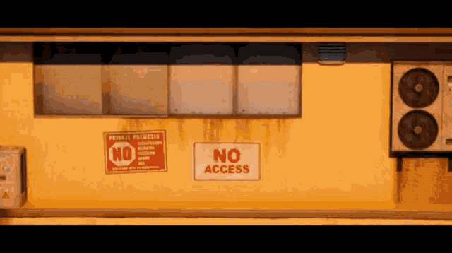 a yellow building has a sign that says no access