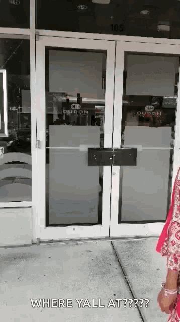 a woman standing in front of a door that says where yall at on it