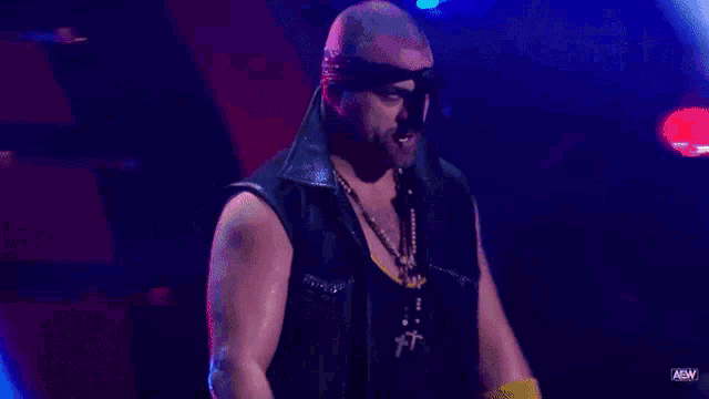 a man with a bandana on his head is standing in front of a blue light