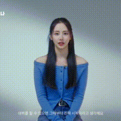 a woman with long hair is wearing a blue off the shoulder sweater .