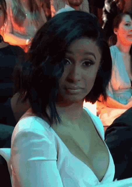 a woman with a very plunging neckline is sitting in a crowd