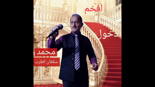a man in a suit and tie is singing into a microphone in front of stairs