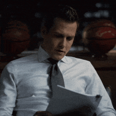 a man in a suit and tie reads a piece of paper