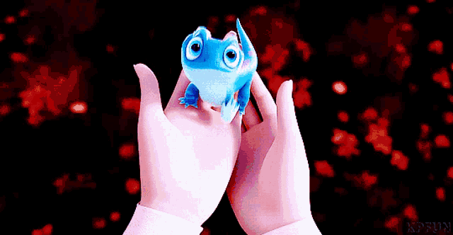 a person is holding a small blue toy in their hands