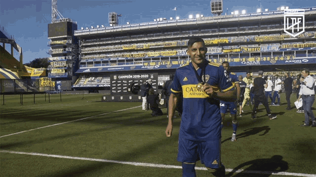 a soccer player wearing a blue jersey that says qatar