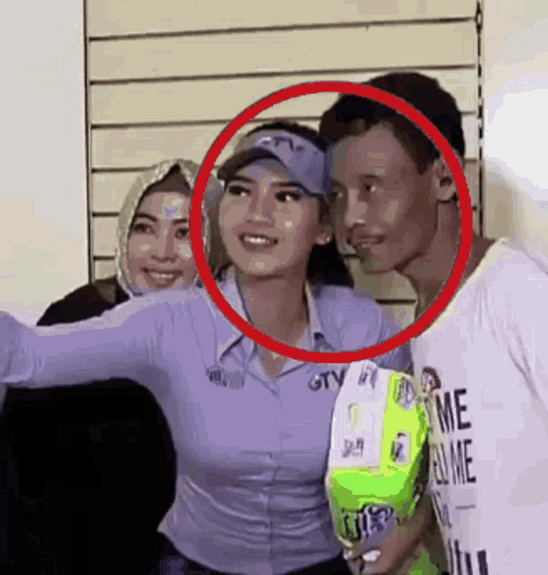 a woman wearing a shirt that says gtv is standing next to a man