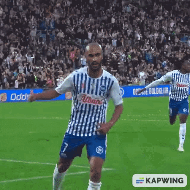 a man in a blue and white striped shirt with the number 7 on the front