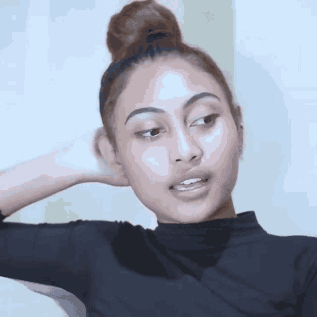 a woman with her hair in a bun has sweat on her arm