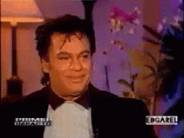 a man in a tuxedo is smiling in a primer unidad video