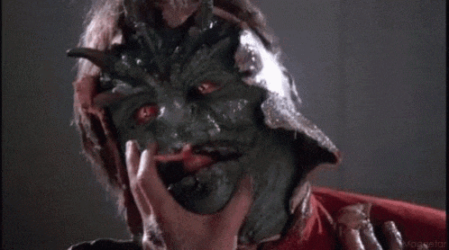 a close up of a person touching a monster 's face with their hand .