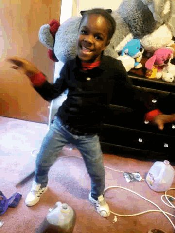 a little girl is dancing in a room with stuffed animals and a gallon of milk