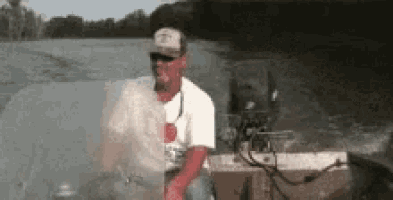 a man in a hat is sitting in a boat on the water