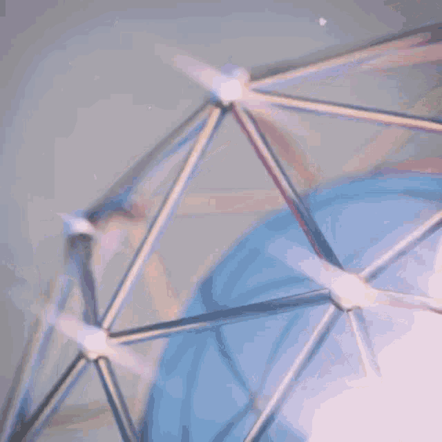 a close up of a metal structure with a blue background