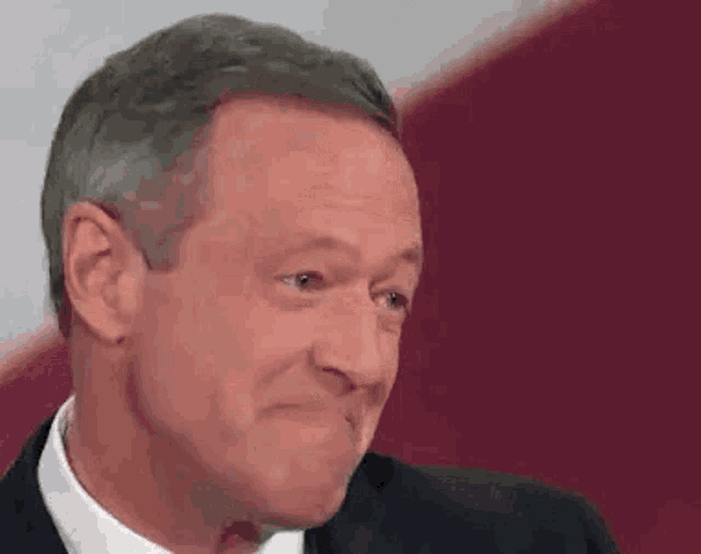 a man in a suit and tie is making a funny face with his mouth open .