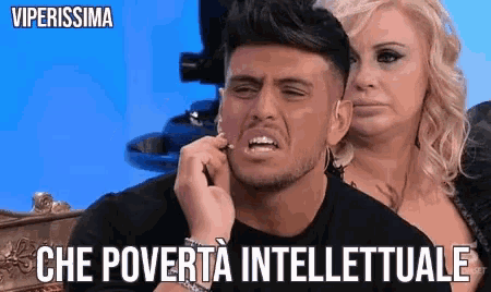 a man with a woman behind him is making a funny face with the words che poverta intellettuale written below him