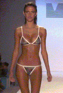 a woman in a bikini is walking down a runway