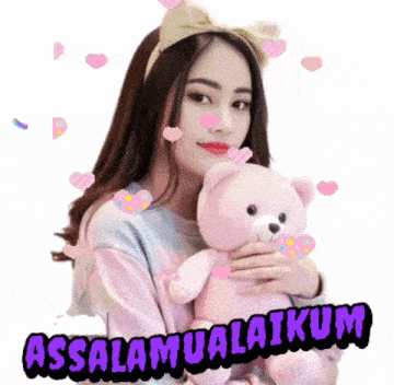 a woman is holding a pink teddy bear with the words assalamualaikum written on it