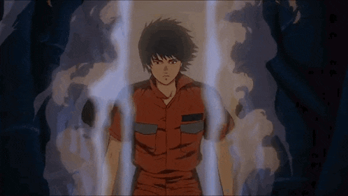 a man in an orange shirt is standing in a dark room with smoke coming out of his mouth .