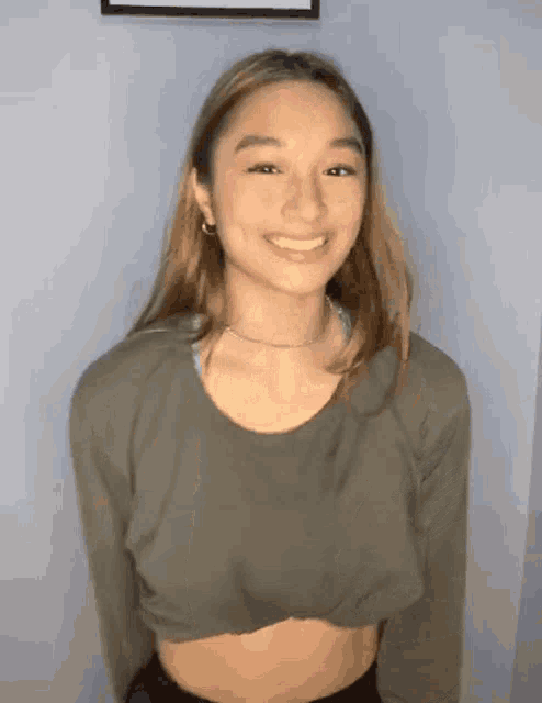 a young woman wearing a crop top and a choker is smiling .