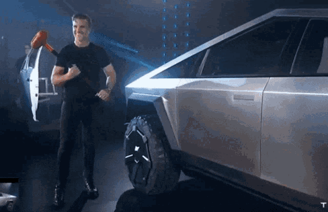a man is standing next to a tesla truck