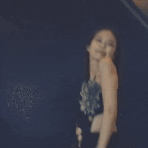 a woman is dancing on a stage in a black dress .