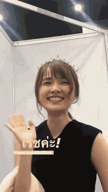 a woman with a tiara on her head is smiling