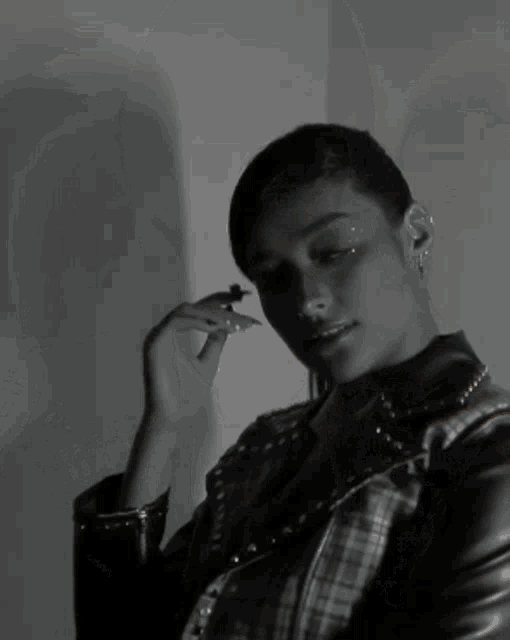 a black and white photo of a woman wearing a plaid shirt and a tie