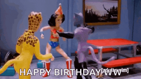 a woman in a wonder woman costume is standing next to a leopard and a cat and says `` happy birthday '' .