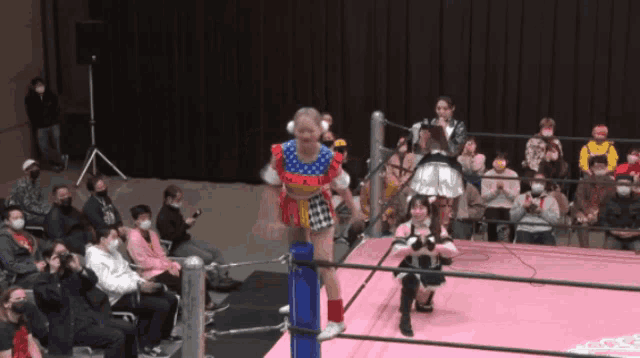 a woman in a colorful outfit is standing on a rope in a ring