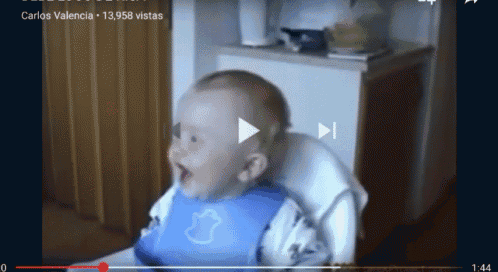 a baby wearing a bib is sitting in a high chair on a video called carlos valencia