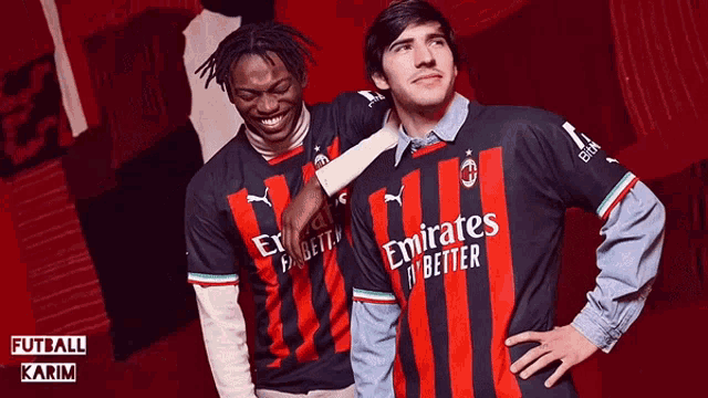 two men wearing emirates fly better jerseys are posing for a photo