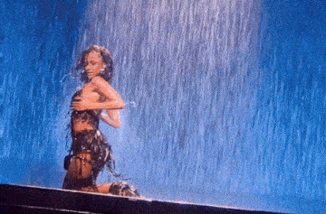 a woman is kneeling down in the rain with her arms outstretched