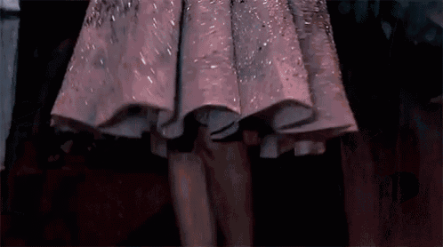 a woman in a pink dress is walking down the runway at a fashion show .