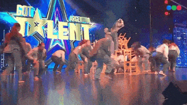a group of people are dancing on a stage in front of a sign that says talent