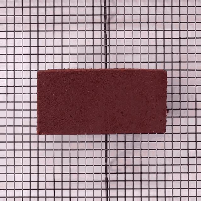 a piece of chocolate cake is on a cooling rack .