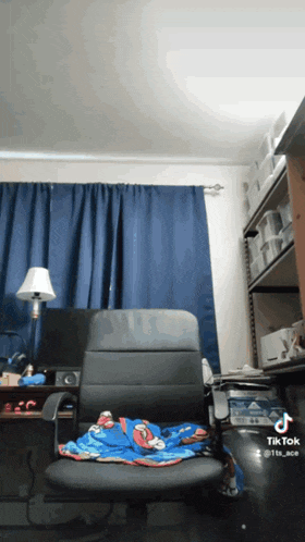 a chair in a room with a blanket on it that says spiderman