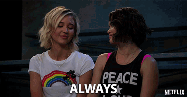 two women are sitting next to each other and one of them is wearing a peace shirt