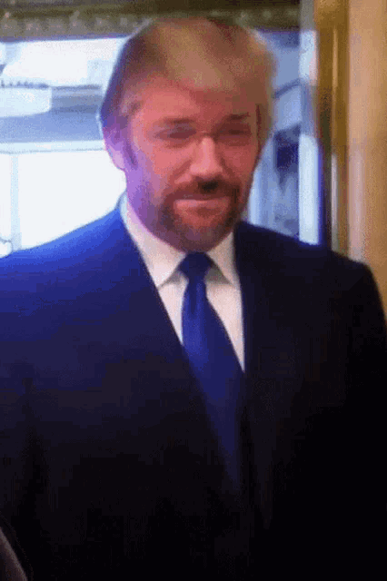 a man in a suit and tie with a fake donald trump head