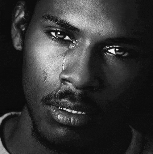a close up of a man 's face with a tear running down his cheek .